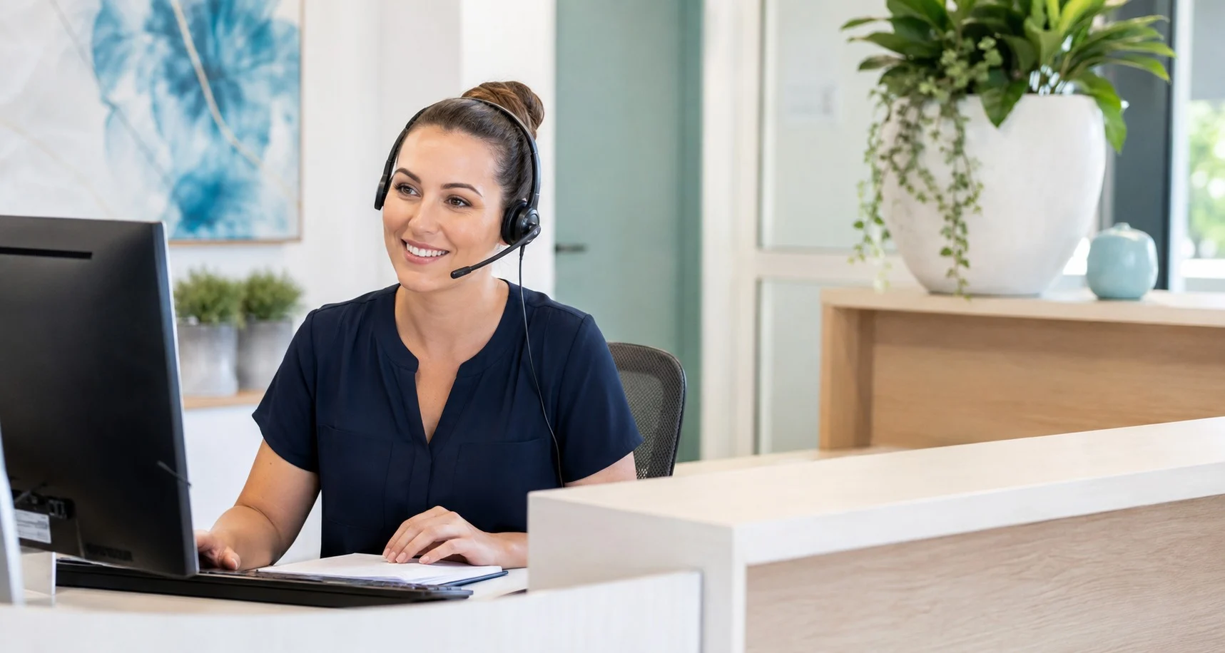 A medical receptionist assisting a caller at the clinic reception desk